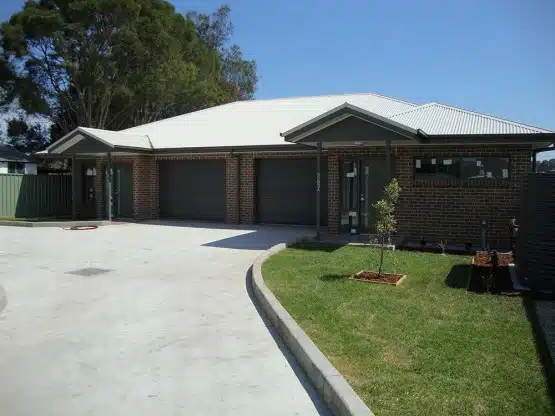 Commercial building with garage doors and landscaped surroundings.