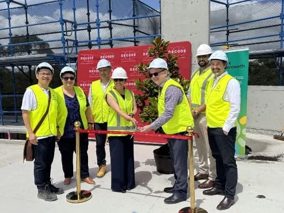 Construction team at Impact Group site with safety gear and high-visibility vests.